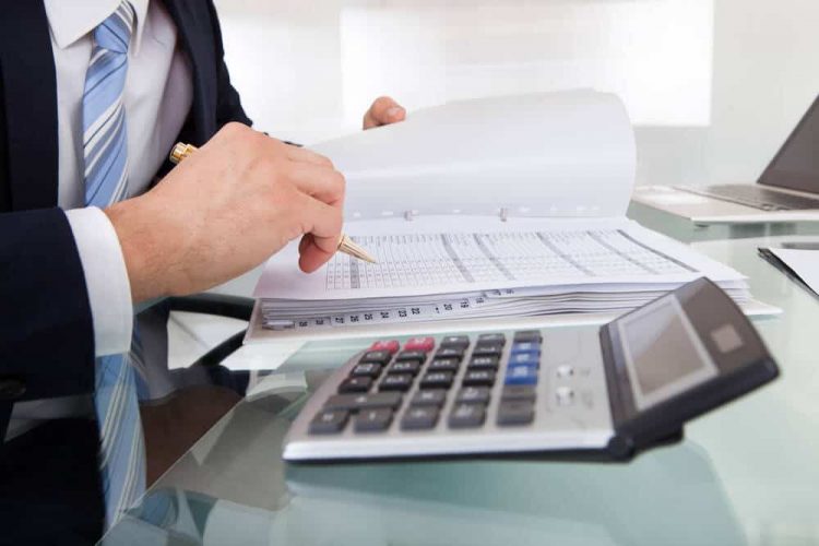 accountant doing expenses calculation on his desk